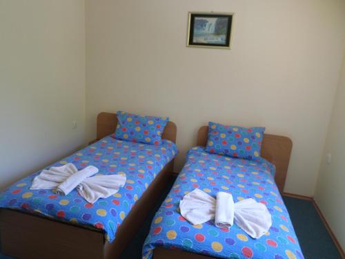 two beds in a room with towels on them at Семеен Хотел "При Мечо" in Rilski Manastir
