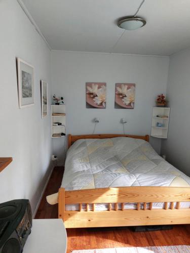 una camera da letto con un letto di legno in una stanza di Ilmastoitu kesämökki Askolassa lähellä Porvoota a Askola