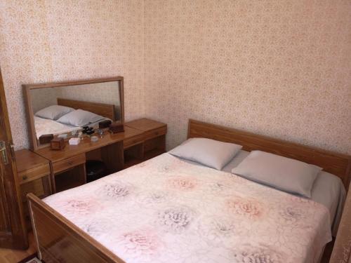 a bedroom with a bed and a mirror at Mariami's sweet home in Kobuleti