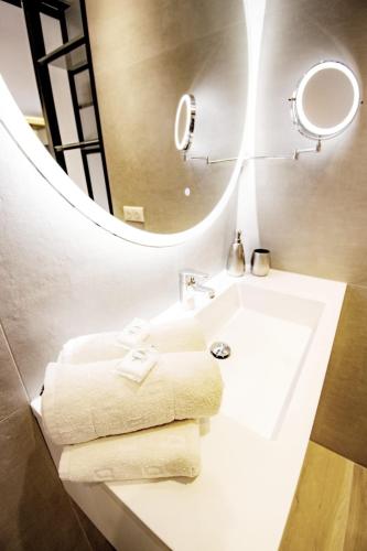une salle de bain avec un lavabo avec un miroir et des serviettes dans l'établissement Exclusif Appart piscine chauffée de luxe 10 min centre AixenPc Belvoir SISSI, à Aix-en-Provence
