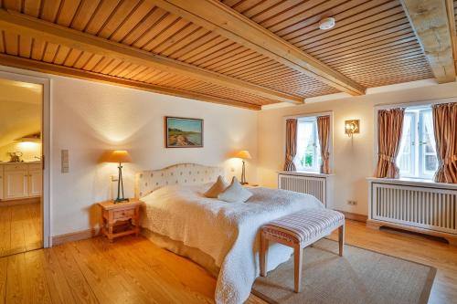 a bedroom with a large bed and two windows at Hotel und Restaurant Jörg Müller in Westerland (Sylt)