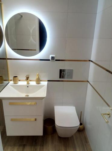 een badkamer met een witte wastafel en een spiegel bij RadkowRynek21 in Radków