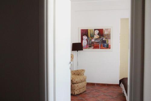 a room with a chair and a painting on the wall at Mila & Aleksandr Apartments in Budva