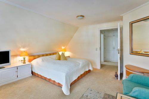 a large bedroom with a bed and a television at Hotel und Restaurant Jörg Müller in Westerland (Sylt)