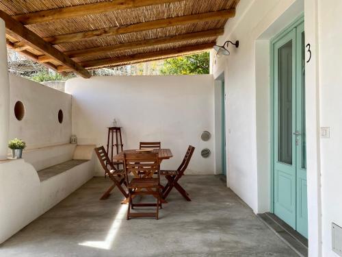 eine Terrasse mit einem Tisch, Stühlen und einer Tür in der Unterkunft Appartamenti Alba&Tramonto in Stromboli