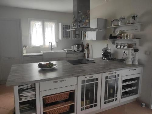 a kitchen with a counter with a bowl of fruit on it at Chez Didier et Myriam in Portiragnes