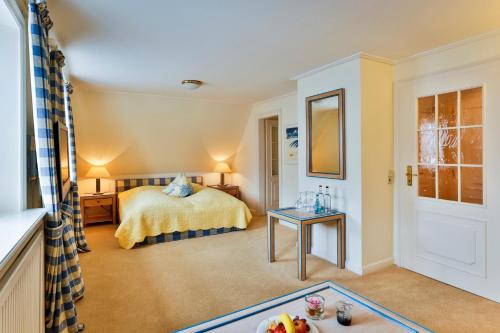 a hotel room with a bed and a table at Hotel und Restaurant Jörg Müller in Westerland (Sylt)