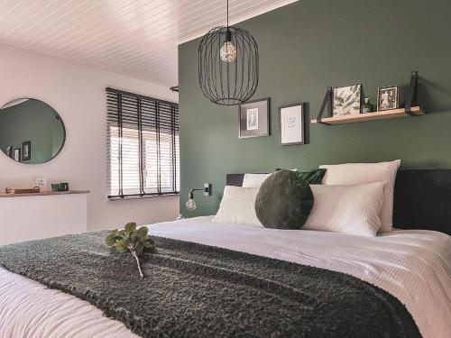 1 dormitorio con 1 cama grande y pared verde en Weynhoven en Brecht