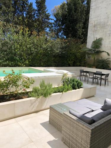 a garden with a patio with a table and chairs at Carlo V - con piscina e giardino privati in Lecce