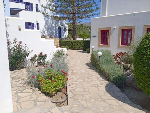 a garden in front of a white building with flowers at Nefeli Hotel Leros in Agia Marina