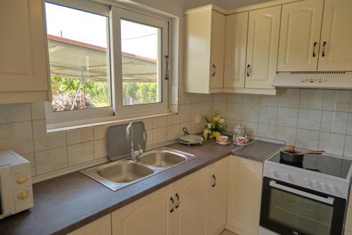 une cuisine avec un évier et une fenêtre dans l'établissement Morfis Getaway Apartment, à Zante