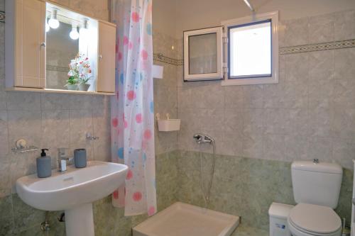 a bathroom with a sink and a toilet and a shower at Morfis Getaway Apartment in Zakynthos