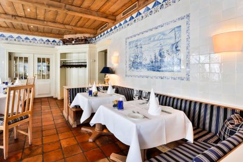 a restaurant with two tables in a room at Hotel und Restaurant Jörg Müller in Westerland (Sylt)