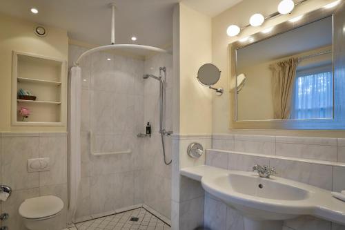 a bathroom with a shower toilet and a sink at Hotel und Restaurant Jörg Müller in Westerland (Sylt)