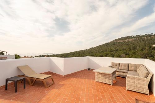 a balcony with a couch and a table at Apartamentos Blanco Sol in Cala Vadella