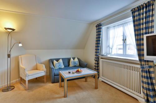 a living room with a blue couch and a table at Hotel und Restaurant Jörg Müller in Westerland (Sylt)