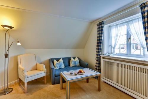 a living room with a blue couch and a chair at Hotel und Restaurant Jörg Müller in Westerland (Sylt)