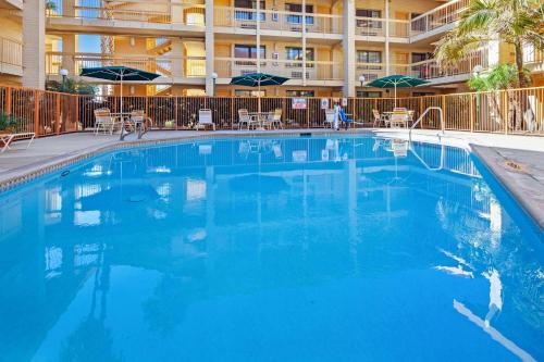 a large blue swimming pool with chairs and umbrellas at La Quinta Inn by Wyndham Ventura in Ventura