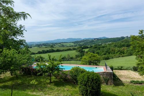 a swimming pool in a field with mountains in the background at Villa Poggio Cherici by Mmega in Rignano sullʼArno