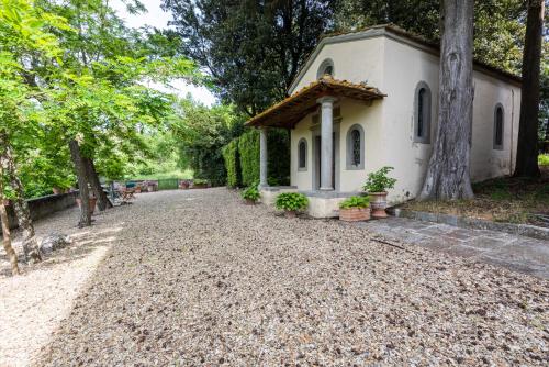 a small white chapel with a gravel driveway at Villa Poggio Cherici by Mmega in Rignano sullʼArno