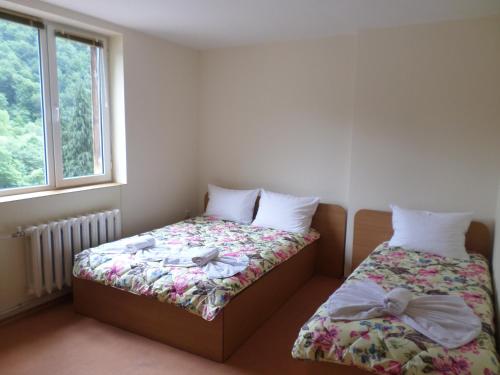 a bedroom with two beds and a window at Семеен Хотел "При Мечо" in Rilski Manastir