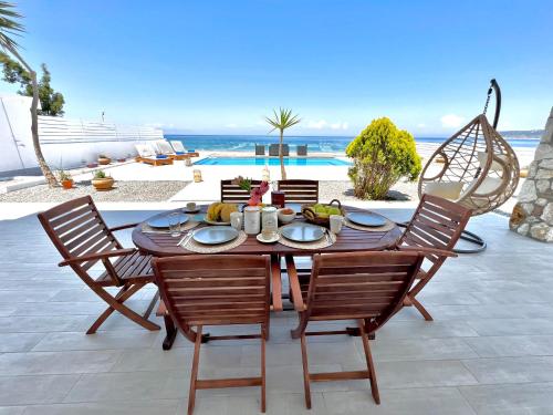 a wooden table with chairs and a table with food on it at Vaso Sea Villa in Ialysos