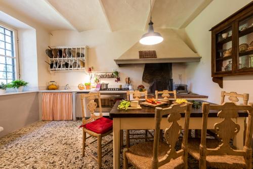 a kitchen with a table and chairs in a room at Villa Poggio Cherici by Mmega in Rignano sullʼArno