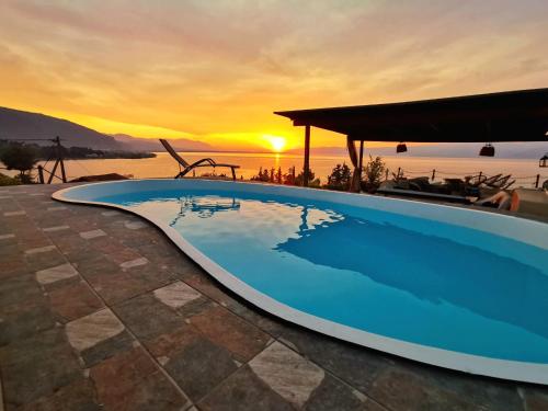a swimming pool with a sunset in the background at Magical view, Villa Asproneri, Kamena Vourla in Kamena Vourla