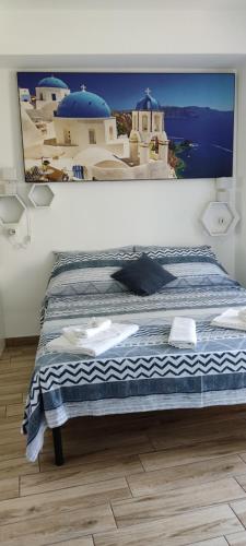 a bed in a room with a picture on the wall at B&B AKROPOLIS in Taormina