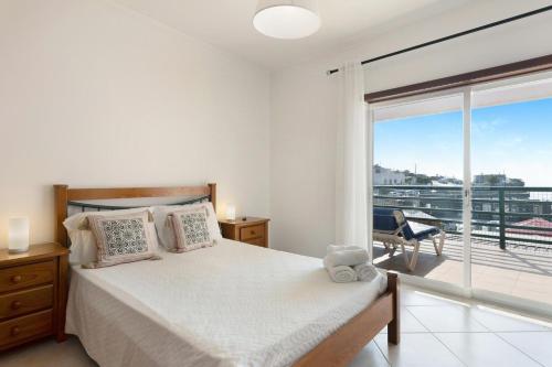 una camera da letto con un letto e una grande finestra di Cantinho da Sara a Portimão