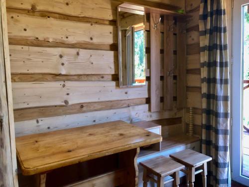 a log cabin with a table and two stools at Аляска in Oryavchyk