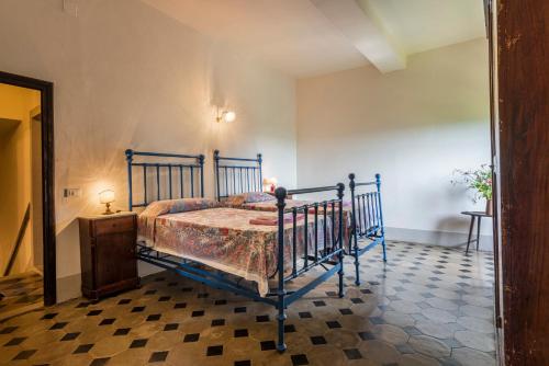 a bedroom with a blue bed and a checkered floor at Villa Poggio Cherici by Mmega in Rignano sullʼArno