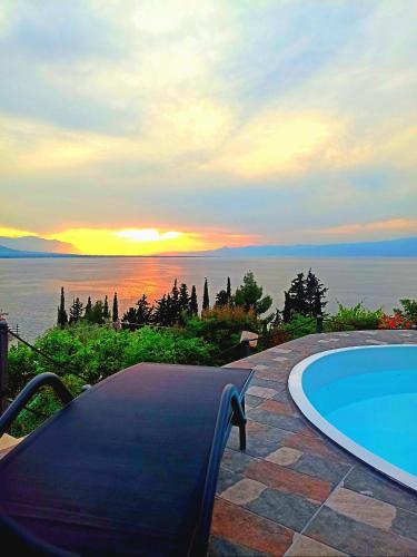 a swimming pool with a sunset in the background at Magical view, Villa Asproneri, Kamena Vourla in Kamena Vourla