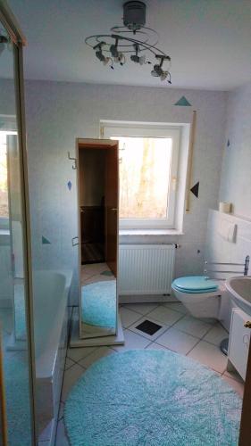 baño con bañera, aseo y ventana en Ferienwohnung am Waldchen, en Bad Kissingen