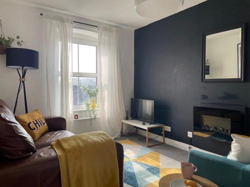 a living room with a couch and a television at 2-Bed Flat in Summerbridge Harrogate Pet Friendly in Harrogate