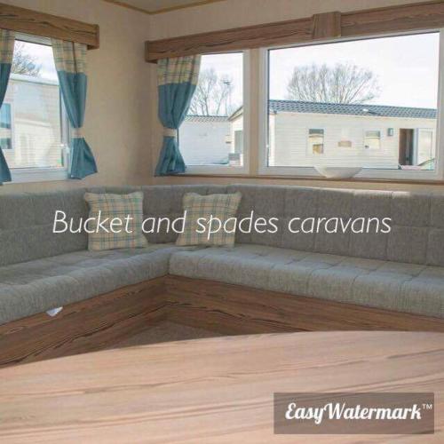 a couch in a living room with two windows at Blackpool caravans Marton mere in Blackpool
