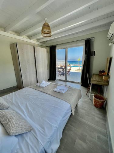 a bedroom with a bed with a view of the beach at Vaso Beach Front Villa in Ialysos