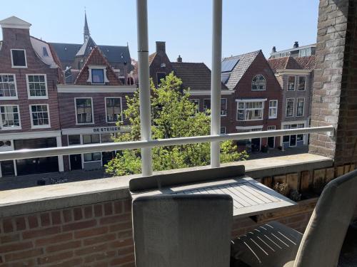 a balcony with a table and chairs and a view of buildings at Lovely City Center Apartment in Alkmaar