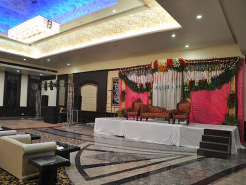a room with a stage with two chairs and a altar at Hotel Sepal in Bathinda