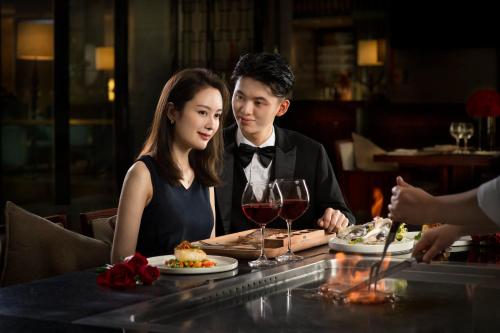 a man and a woman sitting at a table in a restaurant at Crowne Plaza Shenzhen Longgang City Centre by IHG in Longgang