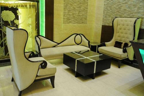 a living room with two chairs and a couch and a table at Hotel Sepal in Bathinda
