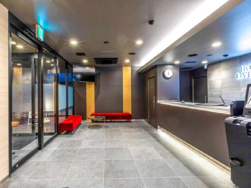 a lobby with a red bench and a waiting room at HOTEL LiVEMAX Okazaki in Okazaki