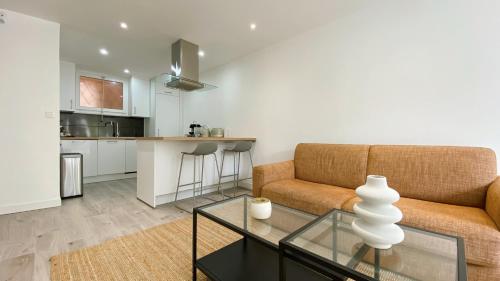 un salon avec un canapé et une table dans l'établissement Vilmorin Appartement 1 Chambre proche de gare, plage, centre, à Antibes