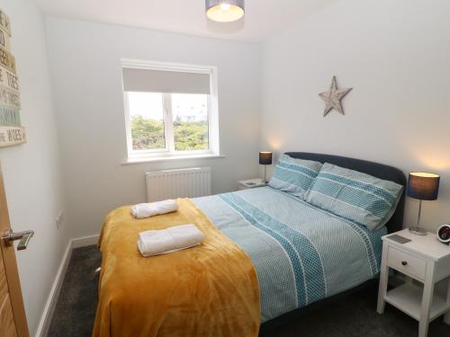 ein Schlafzimmer mit einem Bett mit zwei Handtüchern darauf in der Unterkunft Beach Apartment 9 in Trearddur