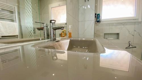uma casa de banho branca com um lavatório e uma janela em Vilmorin Appartement 1 Chambre proche de gare, plage, centre em Antibes