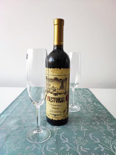 a bottle of wine sitting next to two wine glasses at Quiet and Cozy 2 bedroom flat with free parking included in Floreşti