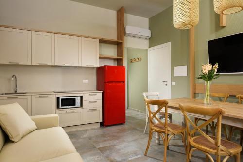 a kitchen with a table and a red refrigerator at Antico Podere San Francesco in Vada