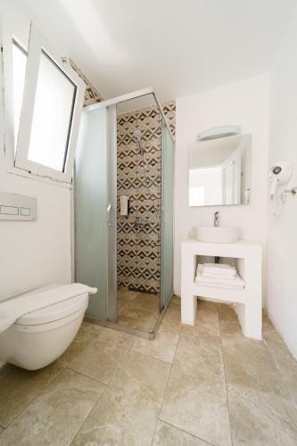 a white bathroom with a toilet and a sink at Costa Sariyaz Hotel Bodrum in Bodrum City