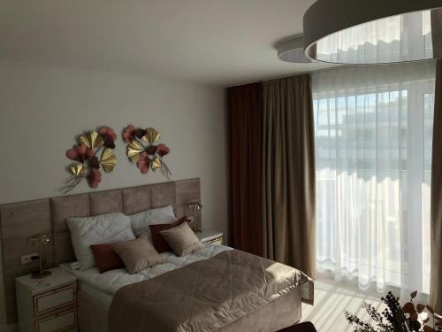 Rogowo Pearl 1510 في روغوفو: غرفة نوم مع سرير مع زهور على الحائط