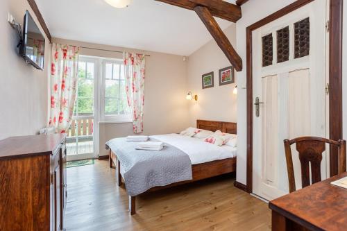 a small bedroom with a bed and a window at Mazurska Leśniczówka Nowy Zyzdrój in Nowy Zyzdrój